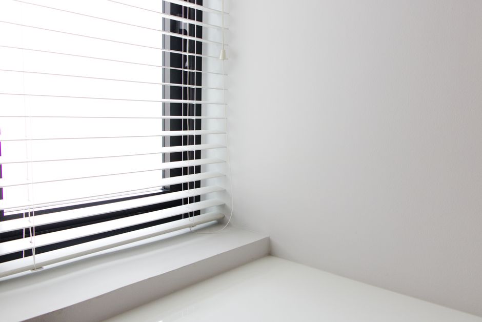 Professional assessing a window for custom blinds installation